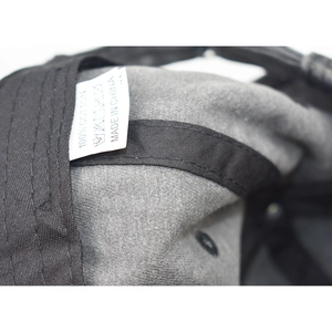 Detail view of the internal 100% cotton wash label and stitching on the baseball cap