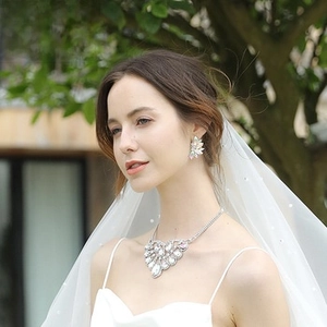 Primo piano di un set di gioielli da sposa scintillanti con collana e orecchini abbinati