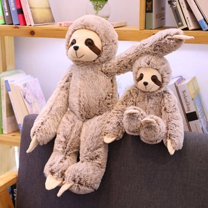 Ensemble de peluches paresseux mère et bébé sur une chaise grise, décor chaleureux