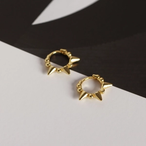 Detail of gold S925 sterling silver hoop earrings with geometric beads and punk spikes