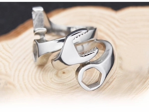 Macro detail of silver stainless steel wrench ring showing industrial biker style textures