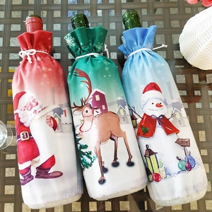 Détails de trois couvre-bouteilles de Noël avec motifs Père Noël, renne et bonhomme de neige