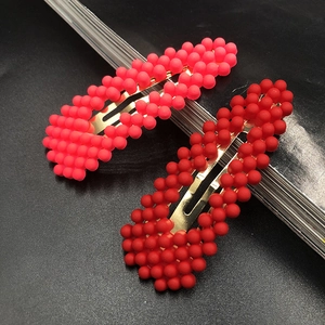 Pink and red beaded oval BB hair clips set on a book page for elegant hair styling