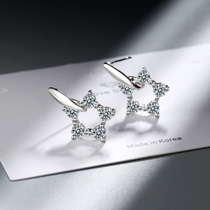 Minimalist silver star stud earrings with sparkling cubic zirconia on a white display card