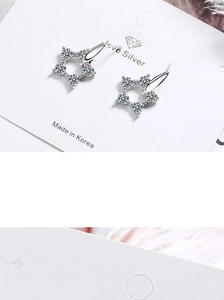 Close-up of star-shaped stud earrings with clear sparkling crystals in silver finish