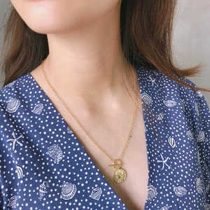 Detail of 925 silver gold-plated double chain necklace with OT toggle clasp and coin charm