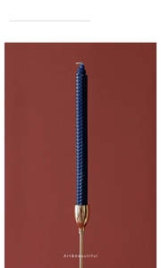 Detail of navy blue honeycomb texture candle on golden brass candle holder ornament
