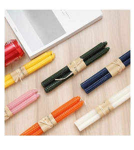 Close-up of assorted colorful beeswax candles with natural honeycomb texture and twine