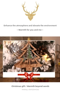 Detail of wooden Christmas tree ornament featuring a laser-cut reindeer and forest scene