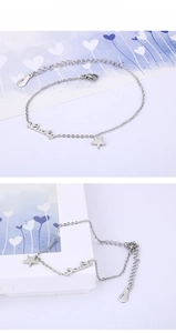 Macro detail of silver star charm and Lucky letter pendant on adjustable metal bracelet