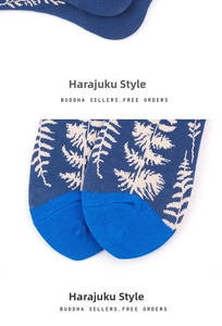 Detail of navy knit socks with beige leaf patterns and bright blue contrast toe design