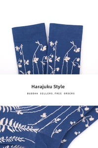 Detail of dark blue crew socks featuring white floral jacquard patterns and ribbed cuffs