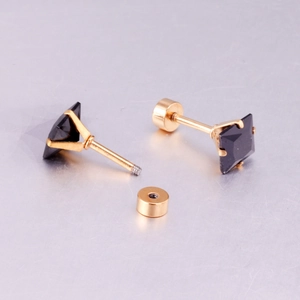 Detail of square black zircon earrings with secure screw-back design and gold finish