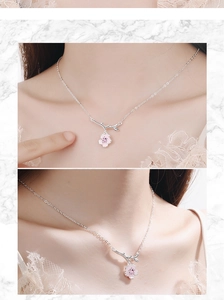 Detail of pink cherry blossom pendant with silver chain and enamel petals on neck