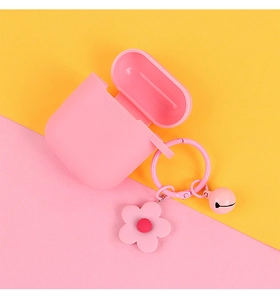 Pink silicone AirPods case with flower charm and bell on vibrant yellow pink background