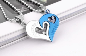 Close-up of interlocking silver and blue heart pendants with I love you engraving
