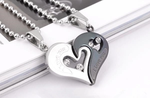 Macro detail of silver and black heart pendant necklace with I Love You engraving