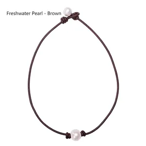 Detail of single white freshwater pearl on brown leather cord necklace with knot closure