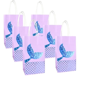 Pink mermaid gift bags with gold foil tails and white rope handles for party favors