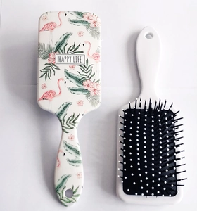 Detail view of square hairbrush with flamingo print and white rounded bristles