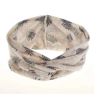 Detail of bohemian twisted headband featuring green palm leaf print on creamy white fabric