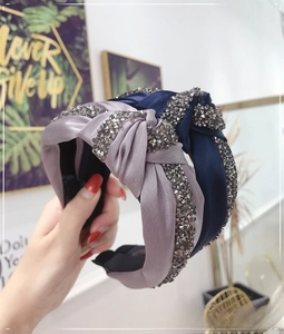 Detail of knotted satin headbands in purple and blue with sparkling grey rhinestones