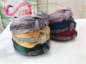 Detail view of various knotted headbands with shiny rhinestones in multiple colors