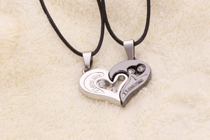 Close-up of heart-shaped couple necklaces with I Love You engraving and rhinestones