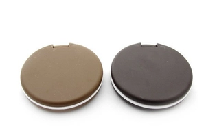 Detail view of mini chocolate cookie compact mirrors in brown and black with white trim