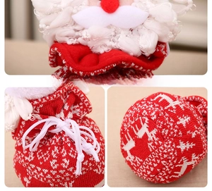 Détail du sac cadeau de Noël tricoté avec motif de renne et charm Père Noël en peluche