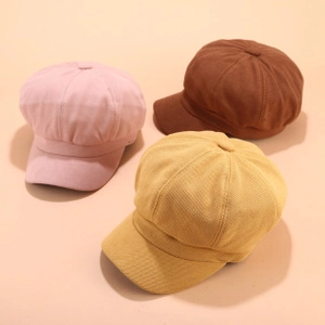 Nahaufnahme von Retro-Schiebermützen in Rosa, Karamell und Gelb aus Cordstoff