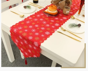 Detailaufnahme von rotem Weihnachts-Tischläufer mit Schneeflocken und Quasten