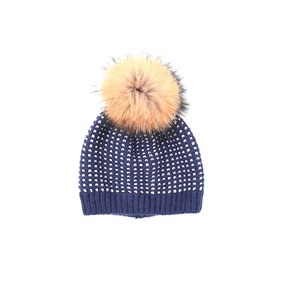 Dettaglio del berretto in maglia blu scuro per bambini con pois dorati e pompon