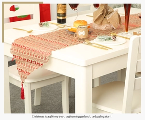 Detailaufnahme des Weihnachts-Tischläufers aus Leinen mit roten Rentier- und Schneeflocken