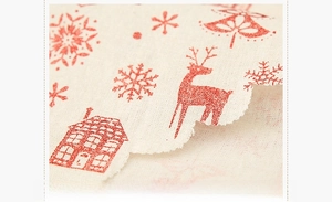 Detailaufnahme von Weihnachtstischläufern aus Leinen mit roten Rentier- und Schneeflocken