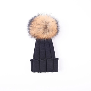 Navy blue winter knitted beanie for children with an oversized fluffy fur pom-pom