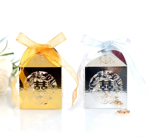 Detailed laser-cut double happiness candy boxes in gold and silver with elegant ribbons