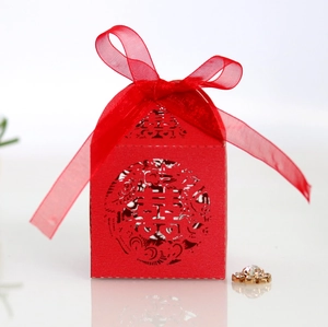 Detail of red Chinese wedding candy box with laser-cut Double Happiness motif and silk ribbon
