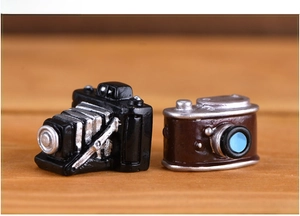 Macro view of vintage miniature resin cameras on a natural textured wooden surface