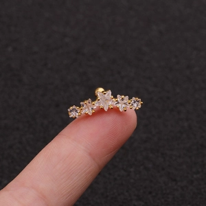 Macro shot of gold surgical steel ear cartilage stud with five star cubic zirconia stones