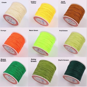 Detailed grid of nylon jewelry cord spools in nine shades of yellow and green