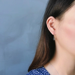 Close-up of minimalist 925 sterling silver safety pin earring worn on the earlobe