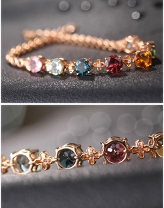 Dettaglio macro del bracciale con gemme colorate e connettori floreali oro rosa