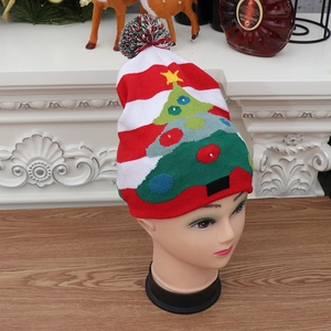 Detail of LED knit Christmas hat with red stripes and glowing green tree pattern