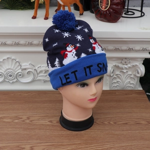 Detail of knitted snowman hat featuring LET IT SNOW text and a colorful pompom