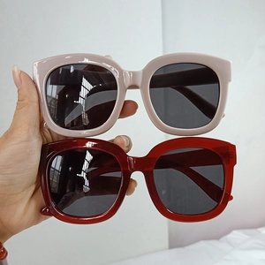 Detail view of square oversized sunglasses in nude pink and dark wine red colors