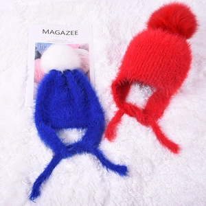 Cozy knit baby winter earflap hats with oversized fluffy pom-poms in blue and red