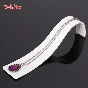 Silver necklace with a purple waterdrop pendant on a white display stand