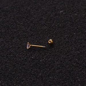 Detailed macro view of a gold stud earring with a square cubic zirconia and ball screw back