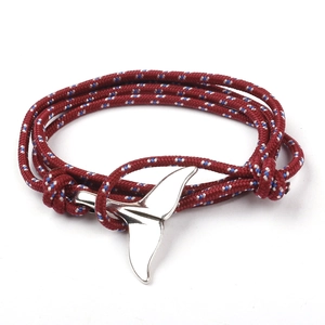 Detail of nautical braided rope bracelet with a silver whale tail metal buckle clasp